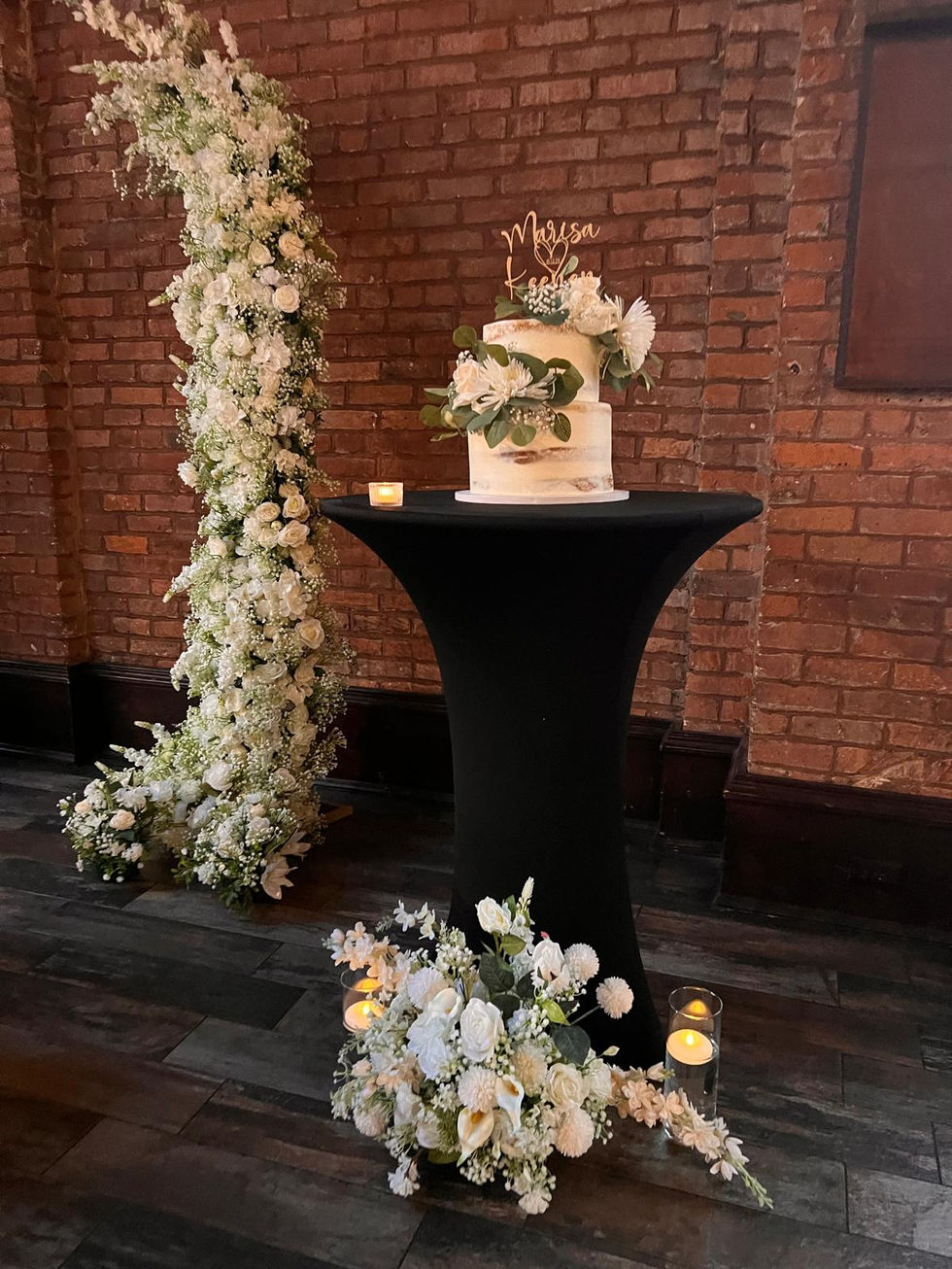 a wedding cake on a table with a sign that says marisa