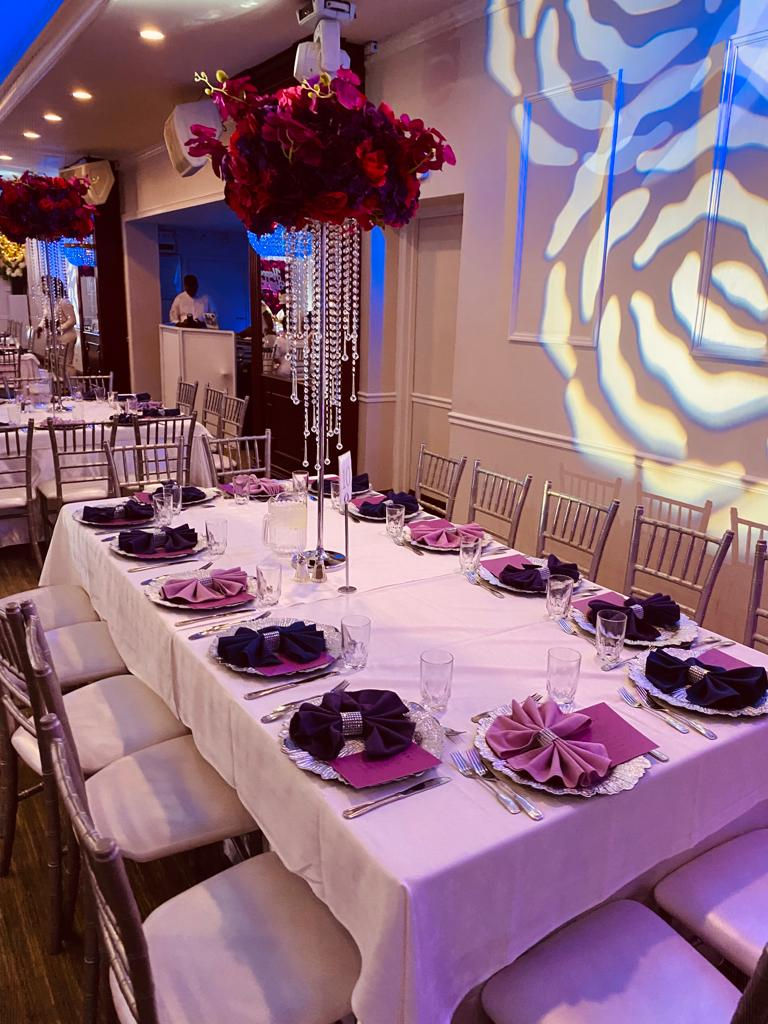 a long table with purple and silver napkins and silverware