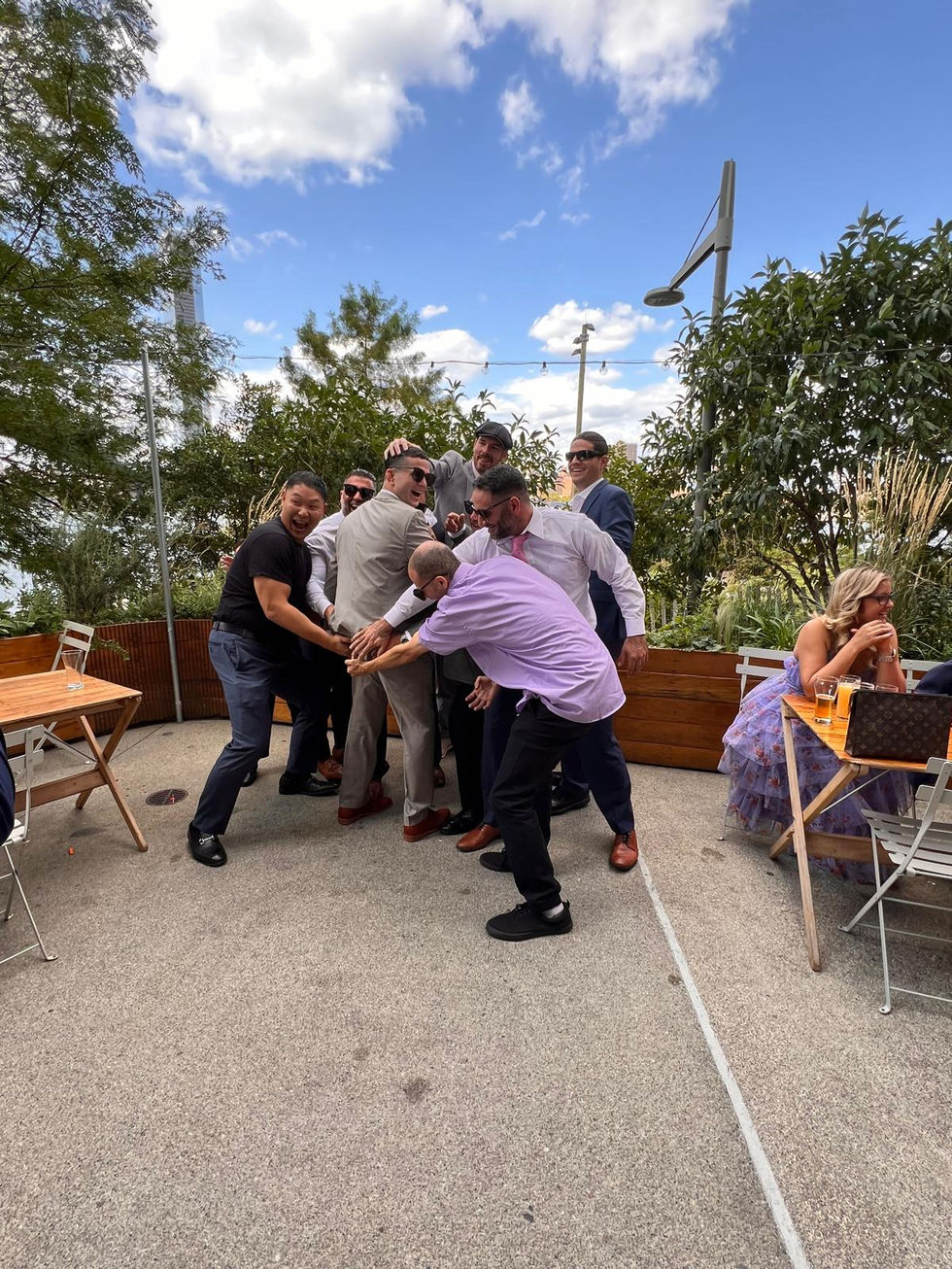 a group of men are posing for a picture on a patio