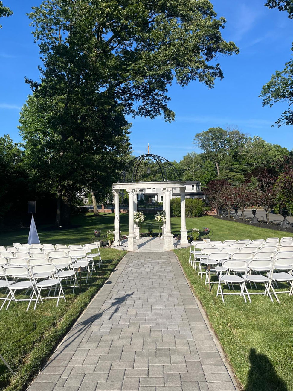 rows of white folding chairs are lined up in front of a white gazebo