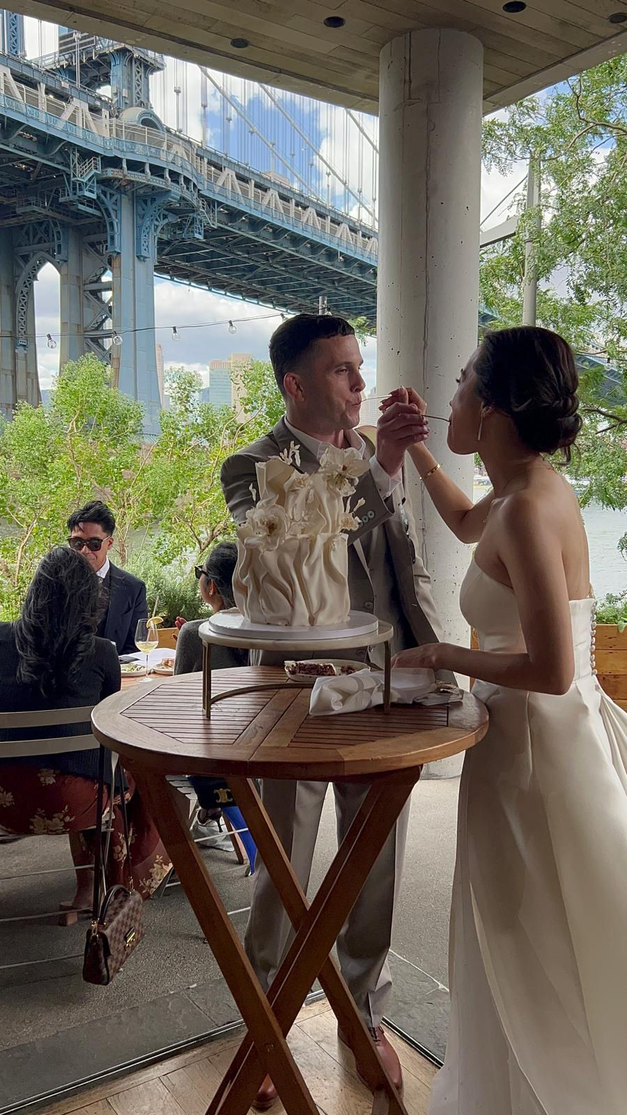a bride and groom are feeding each other their wedding cake