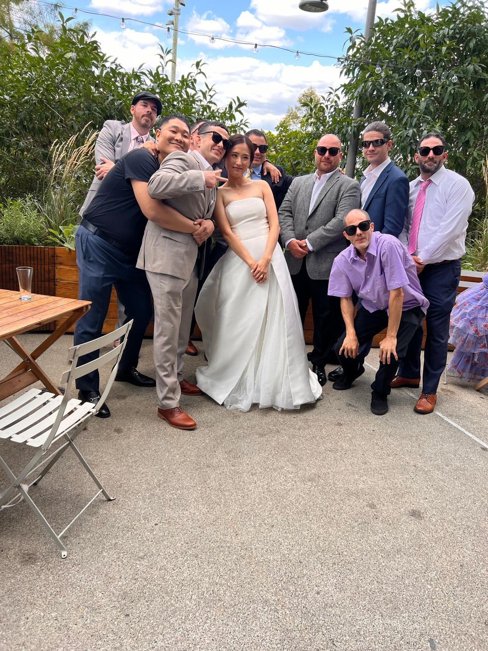 a bride and groom pose for a photo with their wedding party