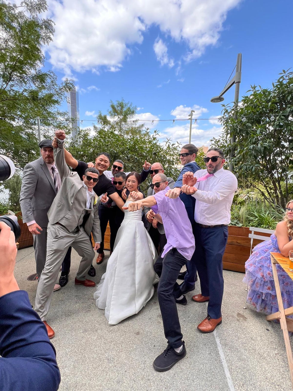 a group of people posing for a picture including a bride and groom