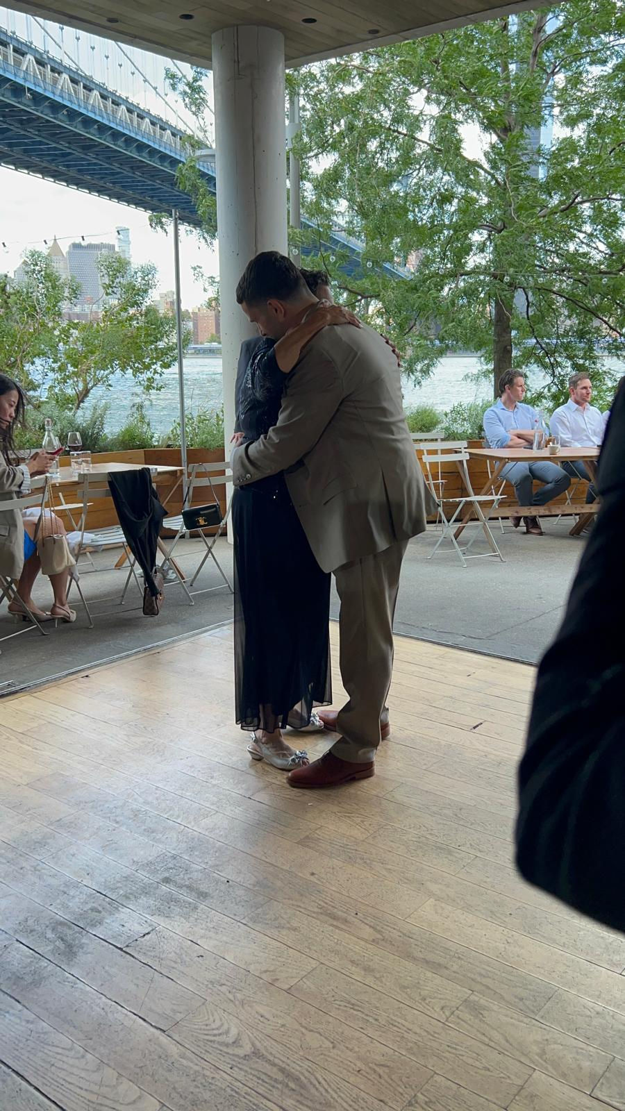 a man in a suit is hugging a woman in a black dress