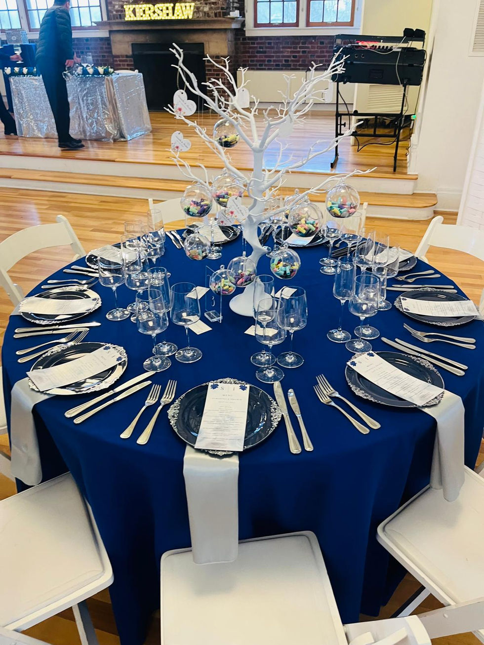 a table set for a wedding reception with a blue table cloth