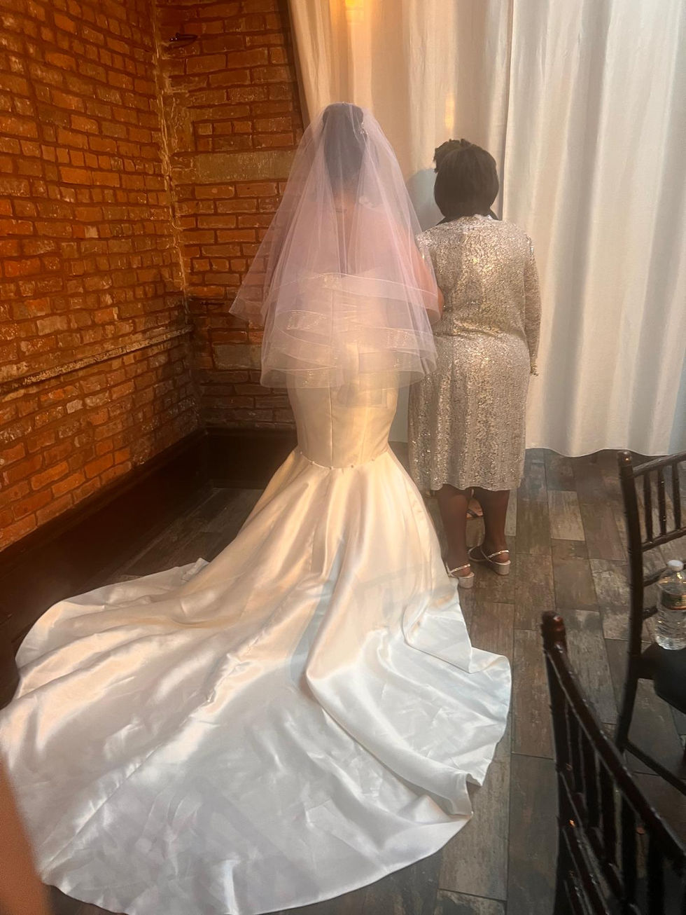 a woman in a silver dress stands next to a woman in a white dress
