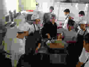 Vicky Acosta, Colombian Celebrity Chef, and Charge d'Affaires ep Alban Carlos Alfonso Franco, speaks with 30 KOTO cooking class trainees.