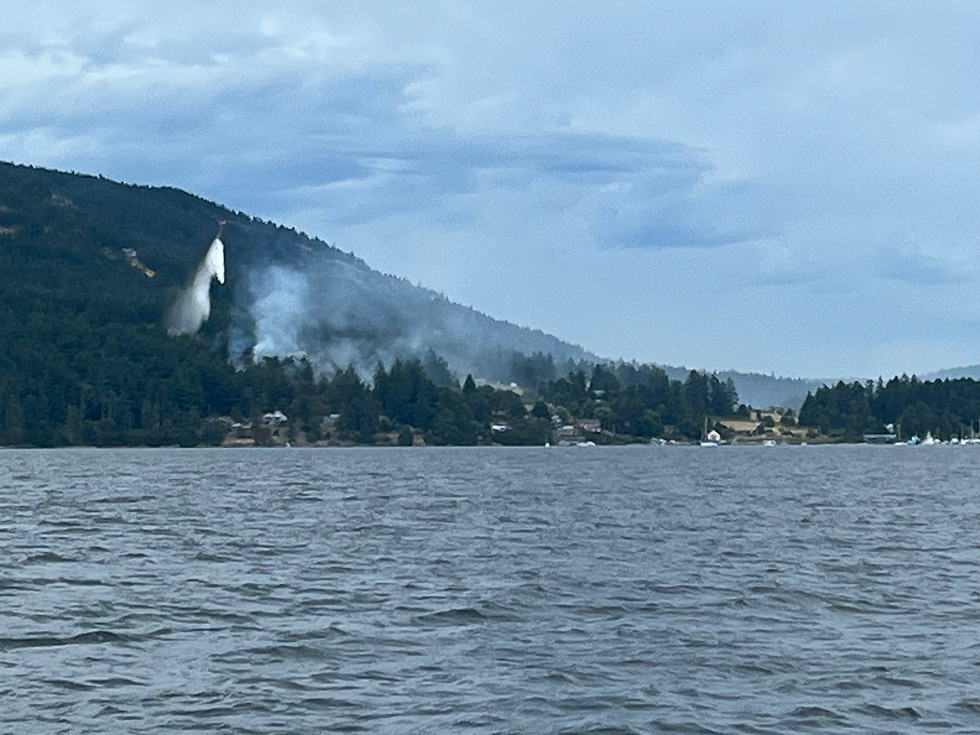 DNR helicopters work to douse the Wildrose Fire on July 9, 2025. Photo captured from the boat of SJICD Executive Director Paul Andersson, just a few miles from the fire.