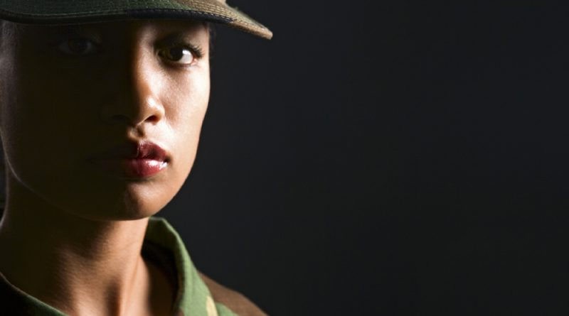 A female soldier stares sadly into the camera.