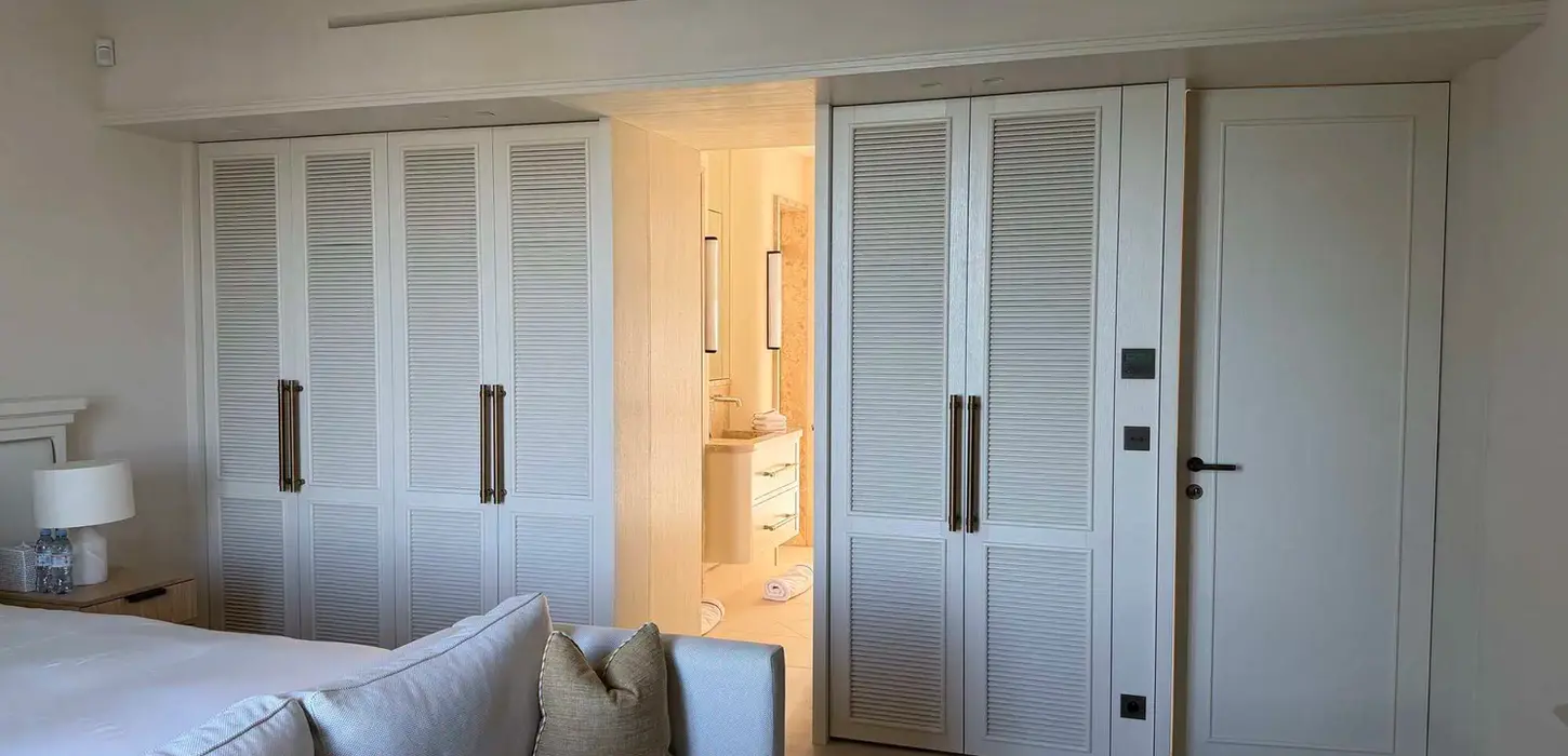 placard sur mesure chambre Monaco laqué blanc portes persiennées poignées laiton éclairage intégré Madrona