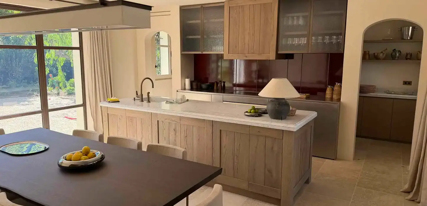 Cuisine ouverte sur mesure en bois naturel avec plan de travail en pierre conçue par Madrona Monaco.