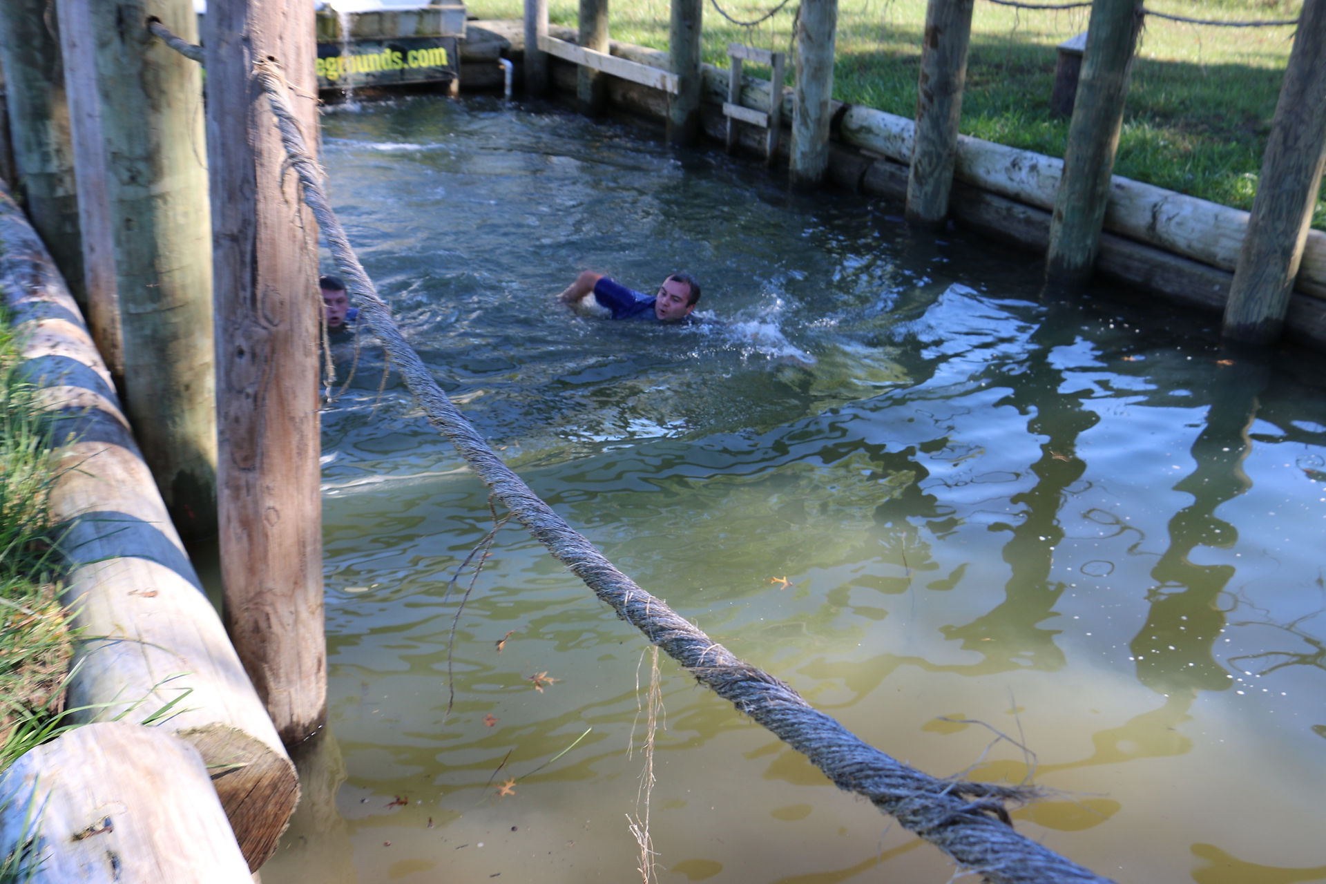 Person swimming in a body of water near a wooden dock