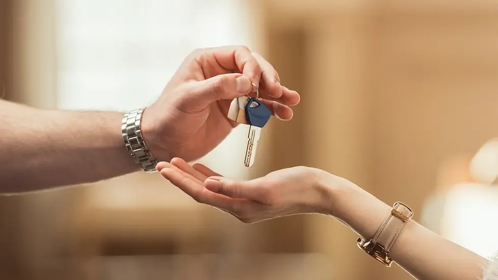 Man's hand gives house keys to a woman's palm.