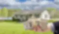 hand with bundles of cash in front of a house