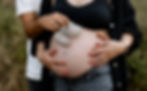 Schwangerer Bauch mit Babyschuhen