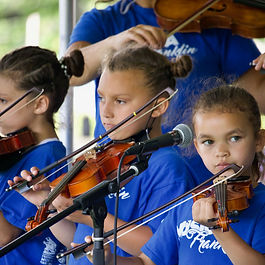 2022/11/16 Picture of three Música Franklin students playing violin