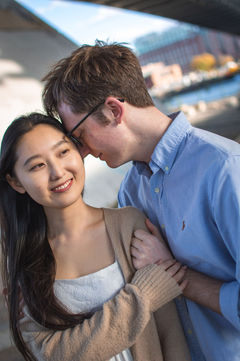 Loving couple smiles under bridge, Cindy and Thomas, enjoying the day together.