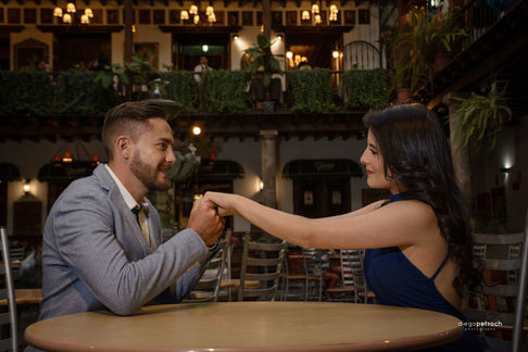Man and woman holding hands at a table, looking at each other.