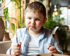 Criança aprendendo a comer, pais com dificuldade de servir comida