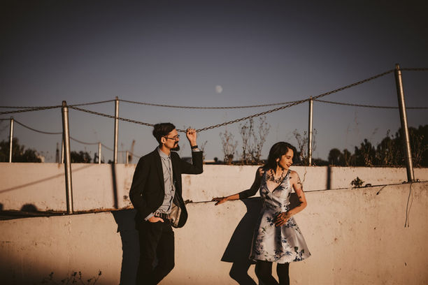 couple standing by fence with moon