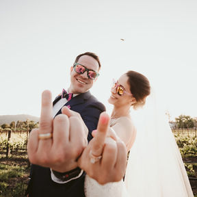 Bride and groom showing off rings