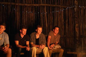 Guests sitting by fire at Kangaroo Valley Bush Retreat.