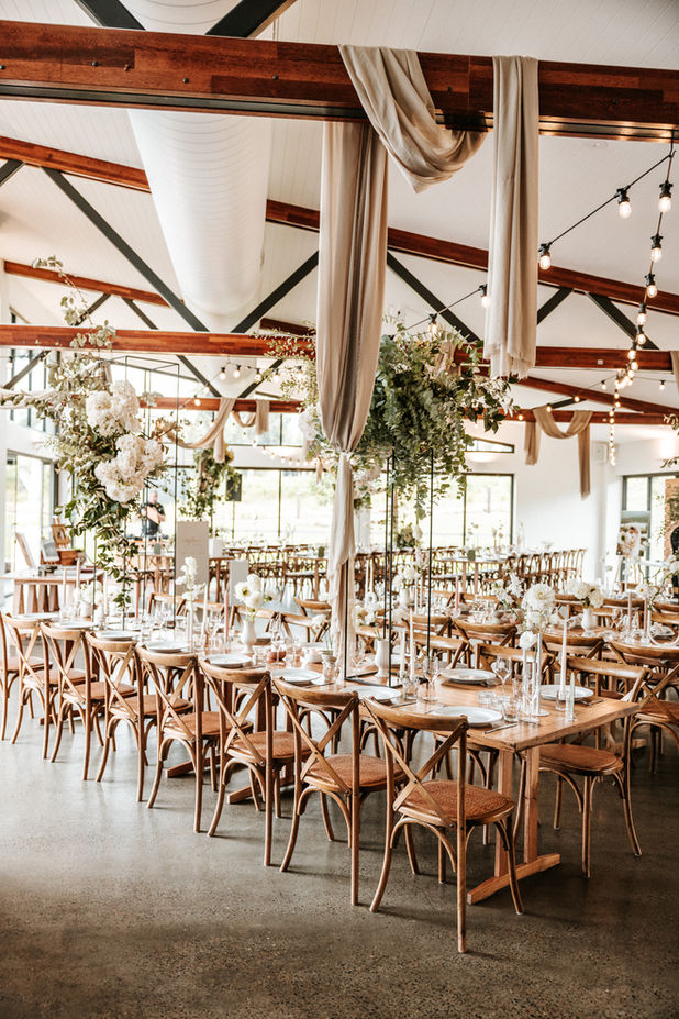 Long banquet tables decorated with greenery and candles at Kangaroo Valley Bush Retreat.