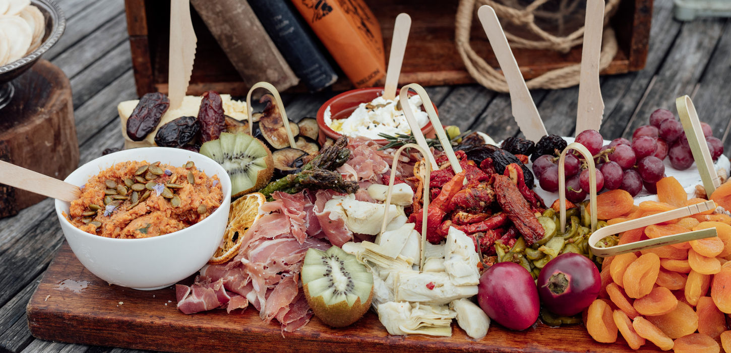 Wedding grazing board with cheeses, meats, fruit, and dips.