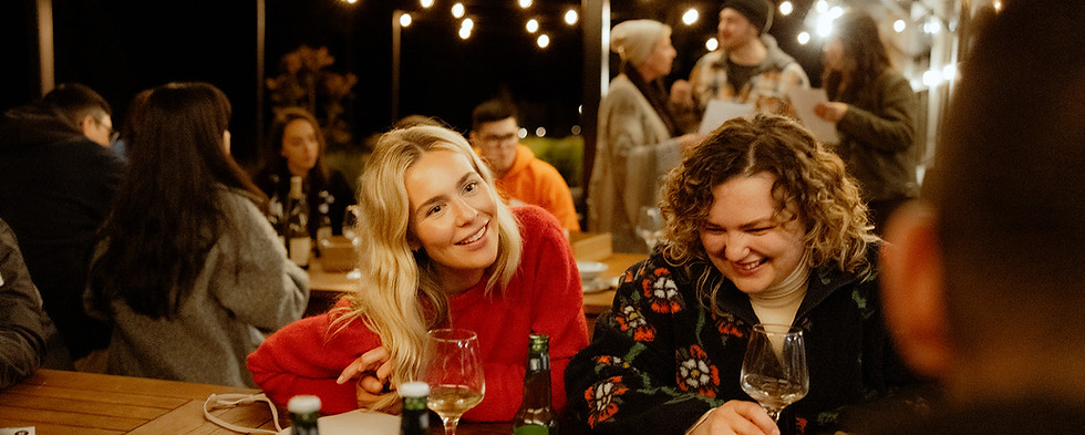 Wedding guests laugh and converse as they settle in the night before the wedding day