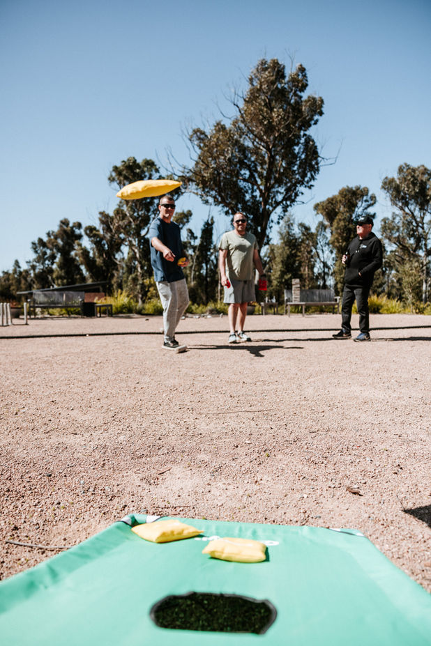 Guests throwing beanbags at cornhole boards in the Games Area at KVBR.