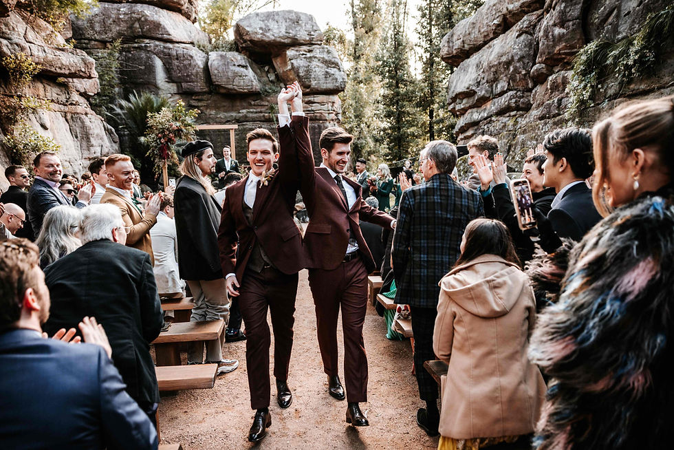 Two grooms sharing their first kiss at the Rock Cathedral during an LGBTQ+ wedding at Kangaroo Valley Bush Retreat.