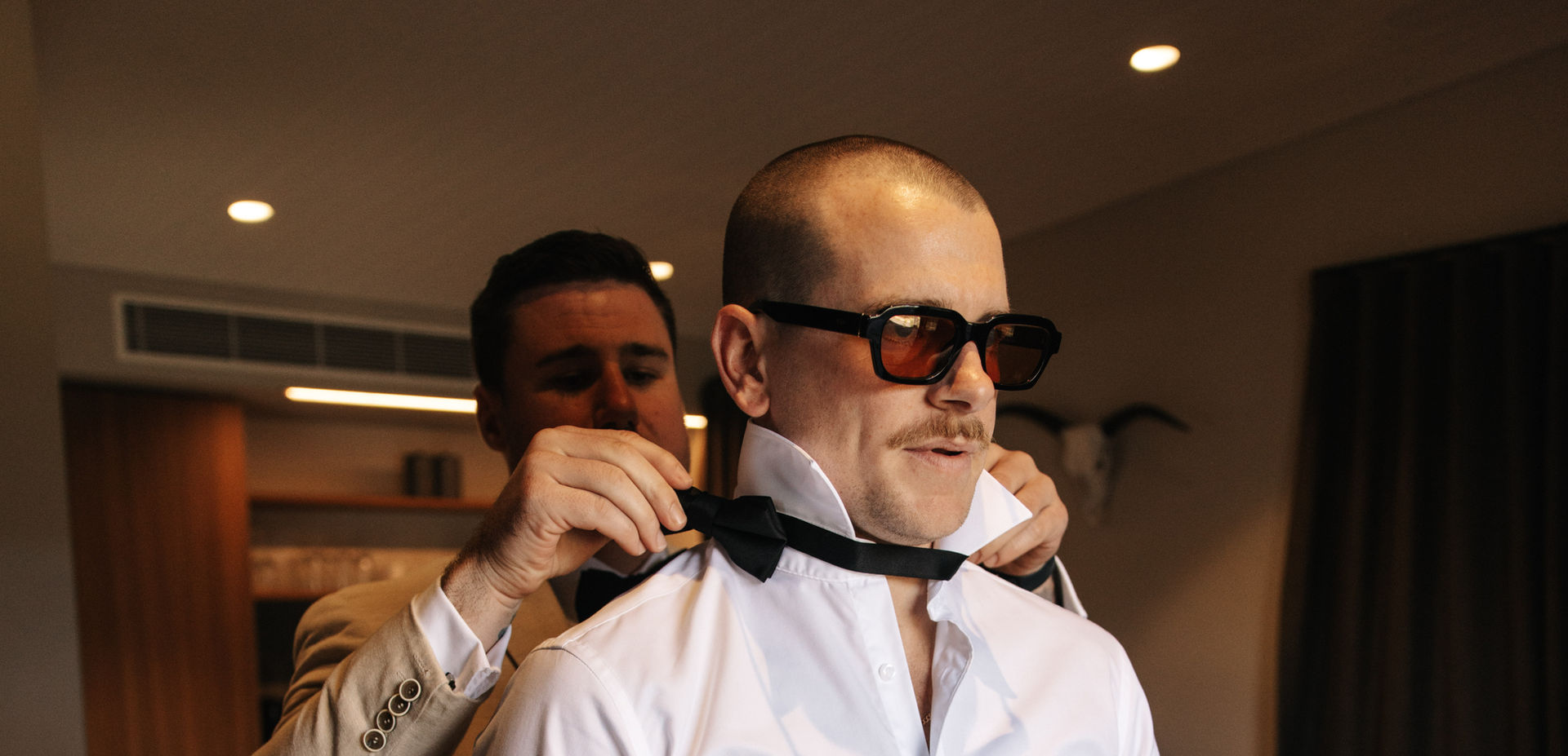 Groomsman helping groom with jacket in Groom’s Suite at KVBR.