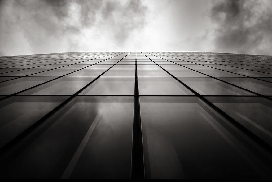 grayscale-low-angle-shot-skyscraper-wall-with-glass-windows-cloudy-sky.jpg