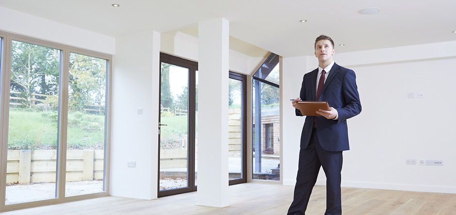 Estate Agent Looking Around Vacant Property For Valuation
