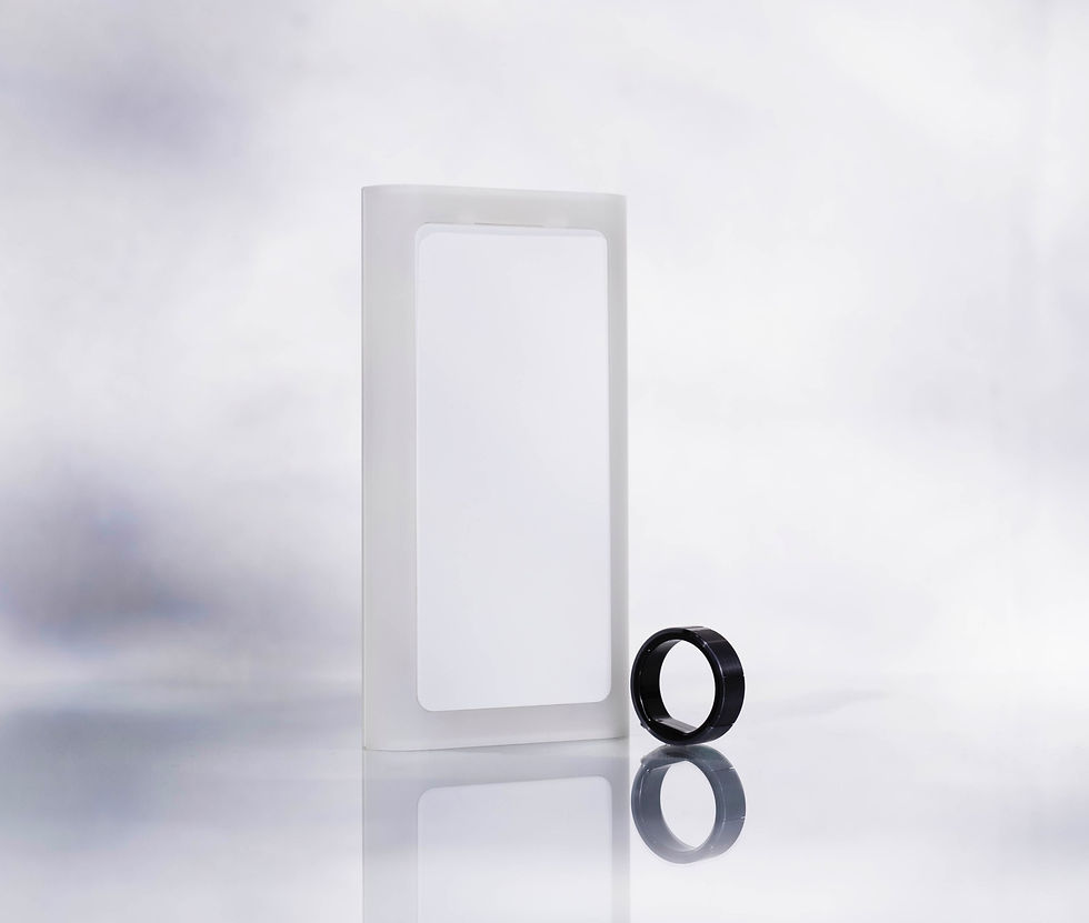 A white rectangular  switch cover upright beside a grey ring.