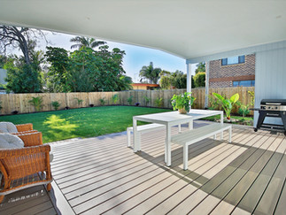 Backyard deck area with green grass and spacious layout.