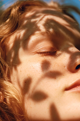 yuvalna_A_close-up_sunlit_portrait_of_a_serene_young_woman_with_86433e81-b401-4e6c-8db0-47