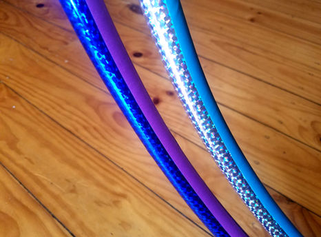 Two prismatic taped hula hoops in blue and silver.