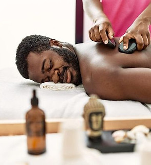 Premium Photo _ African american man reciving back massage with black stones at beauty cen