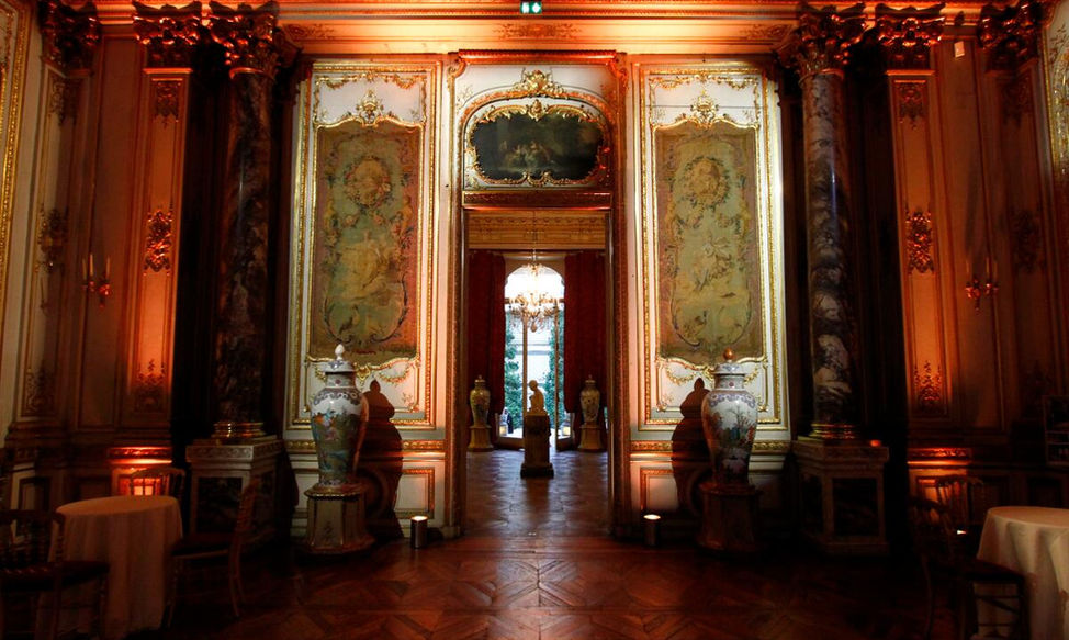 Salon aux boiseries dorées du Musée Jacquemart-André éclairé en soirée, ouvert sur les salles voisines pour un grand cocktail.