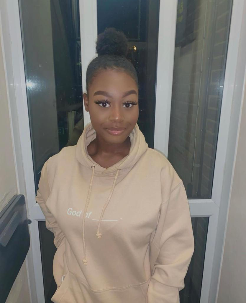 Akua wearing our God of hoodies in sand