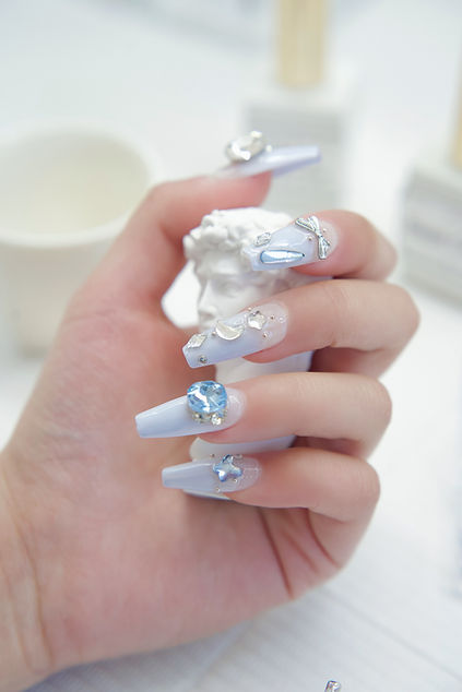 A hand wearing blue Press-on Nails