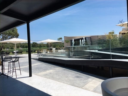 Zona exterior de la zona nueva de la masia remodelada para la realizacion de eventos, con una rampa, pergolas y mesas con taburetes