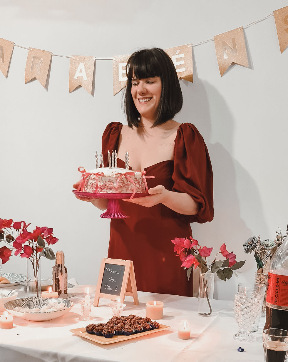 Nutricionista Marcela Camargo segurando seu bolo e feliz! Comemorando seu aniversário sem medo ou culpa em comer o gosta no dia do seu aniversário.