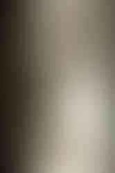 Een moderne kamer met witte maatwerk kasten en een schuin plafond.