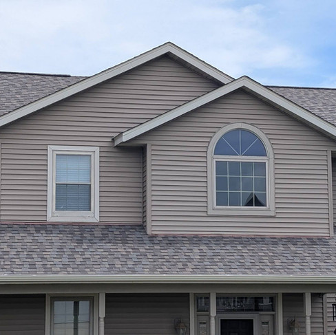brown and grey exterior renovated roof on two story house