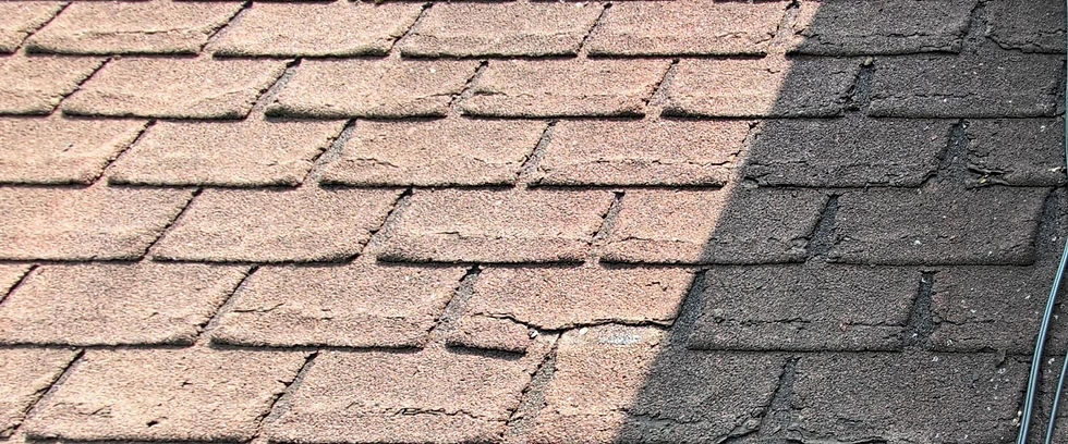 Close-up of old and cracked roof shingles showing signs of wear and tear typical of roofs approaching or exceeding 20 years.