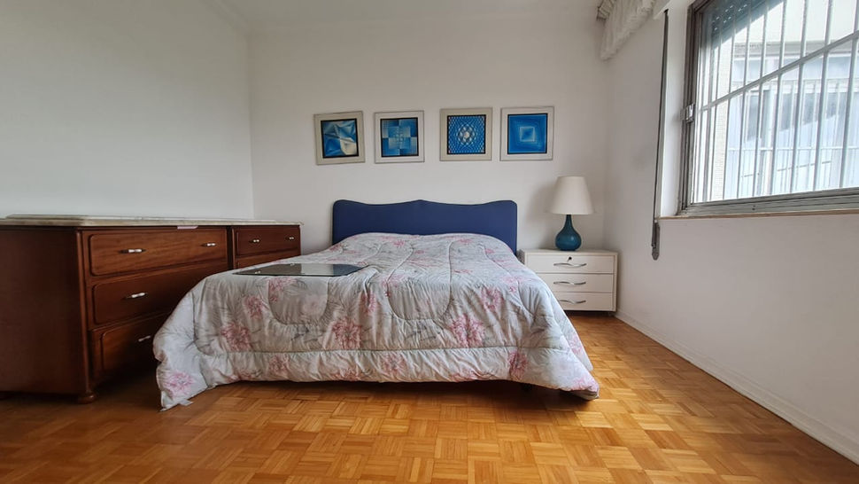 Suíte master da cobertura no Edifício Ibirana com espaço amplo e janelas grandes.