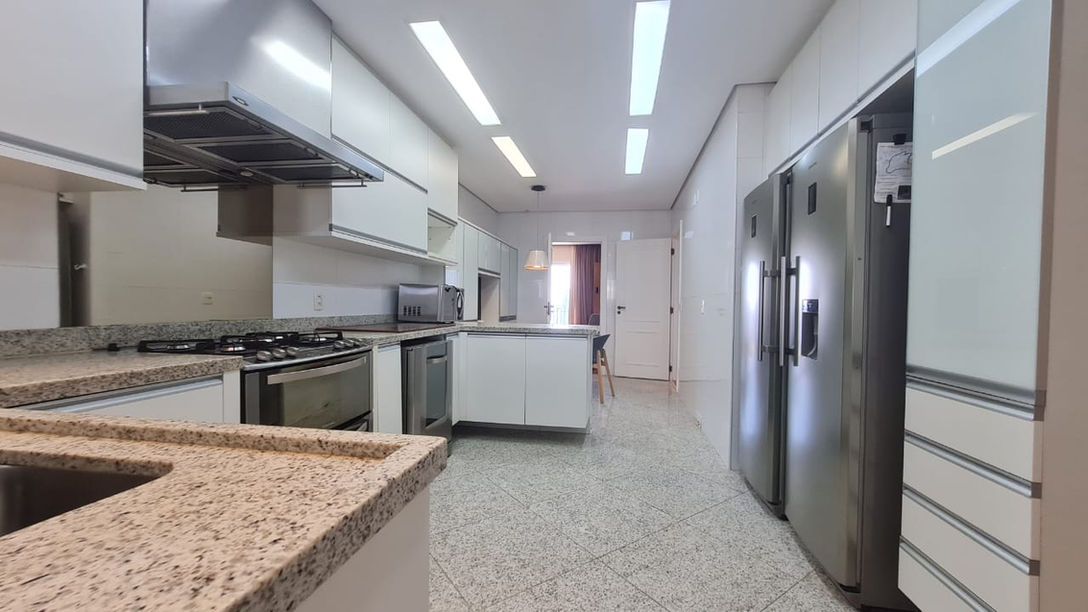 Cozinha equipada com ilha e armários planejados.