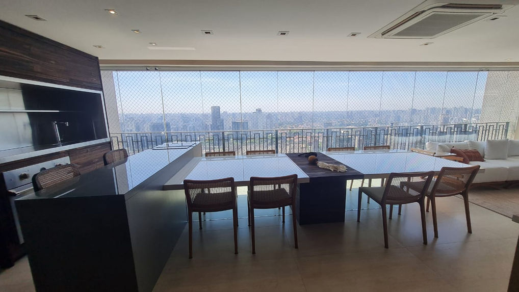 Varanda gourmet com mesa e vista aberta no apartamento em andar alto